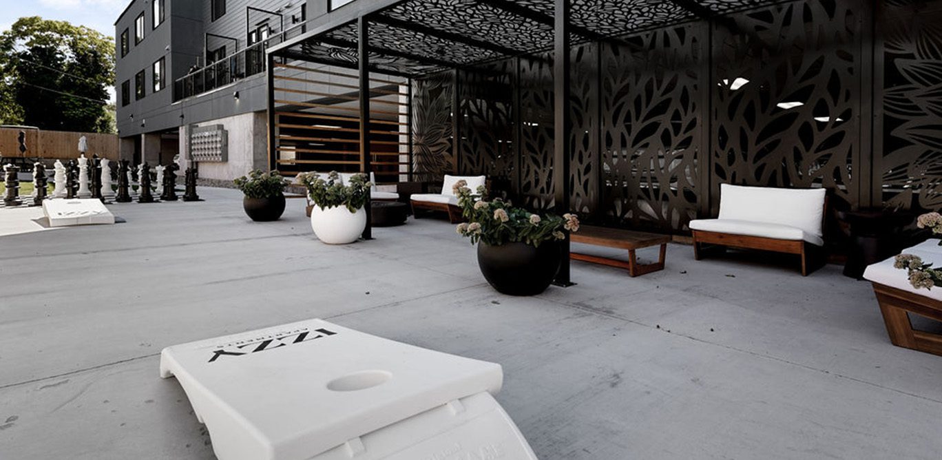 Izzy apartments outdoor lounge with ample seating, gazebo, and bag toss boards.