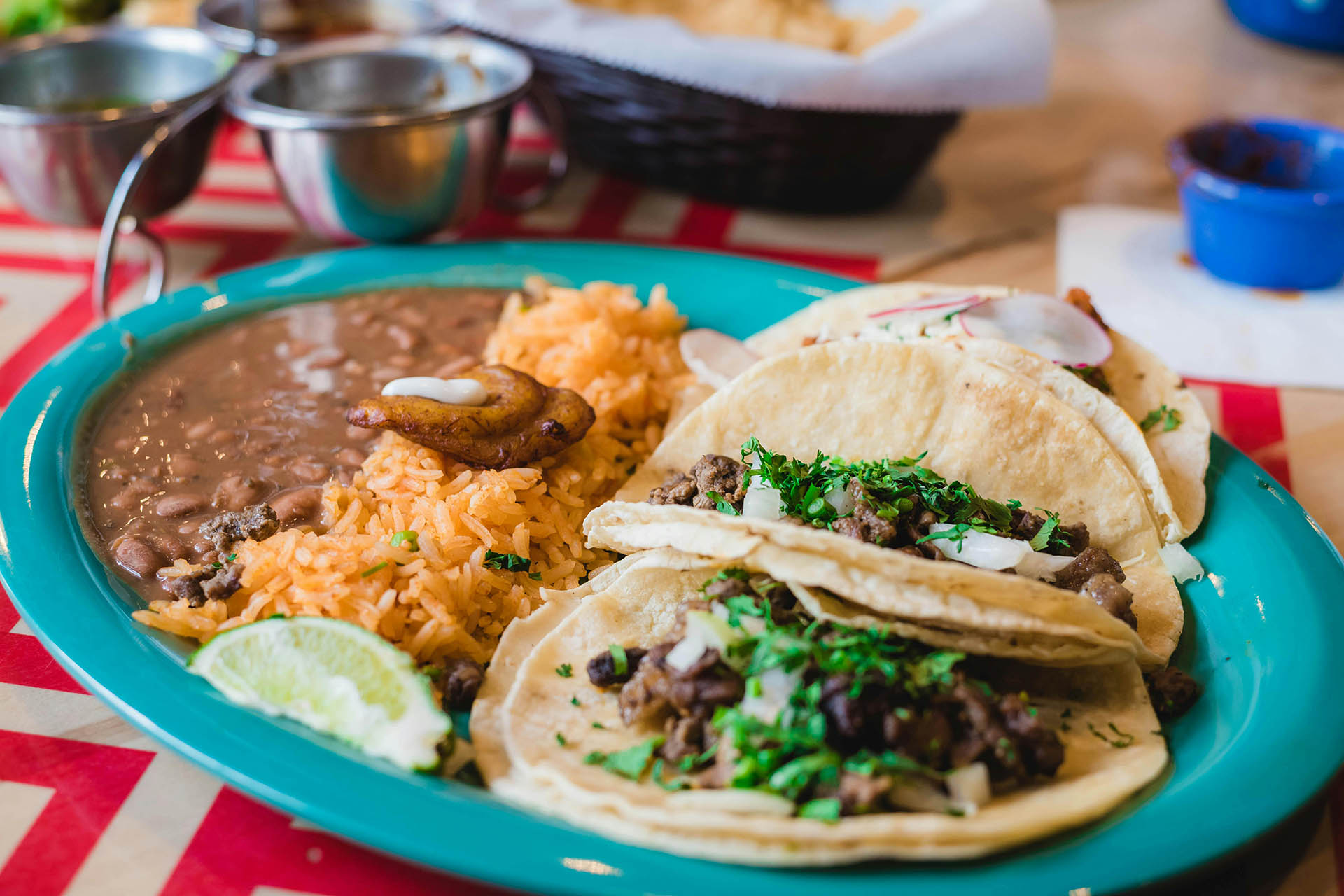 Plate of tacos with rice and beans and chips and salsa.